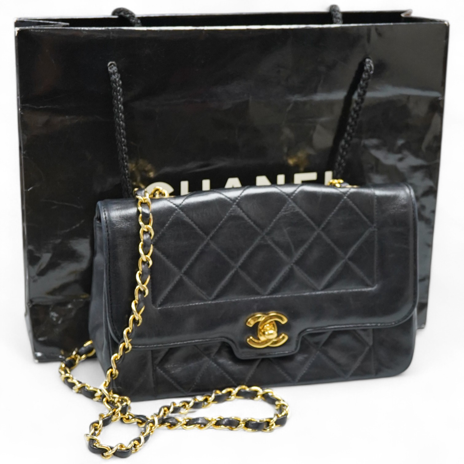 A late 1980’s Chanel black leather Diana shoulder bag with original dust cover and bag, Chanel authenticity card numbered 1944645, interior date code rubbed, 23cm wide, Provenance: Purchased by the vendor, 26 Old Bond St
